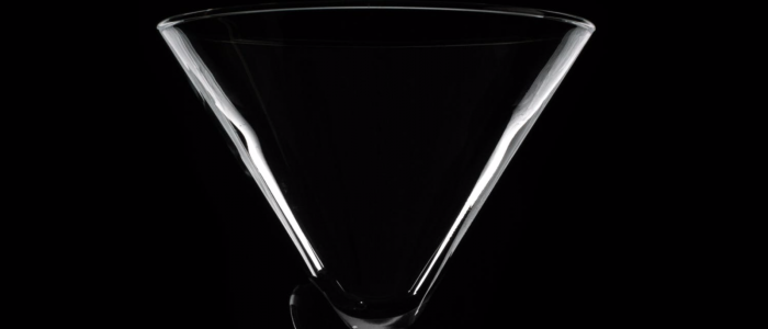 Clear martini glass against black background 