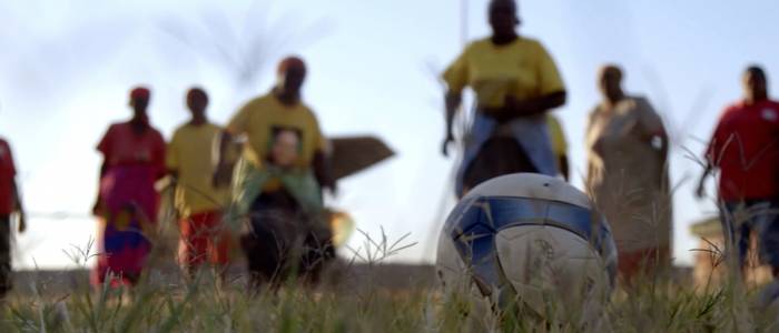 Soccer grannies running towards soccer ball 