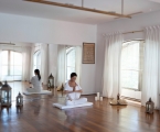 women sit on wood floor in yoga positions